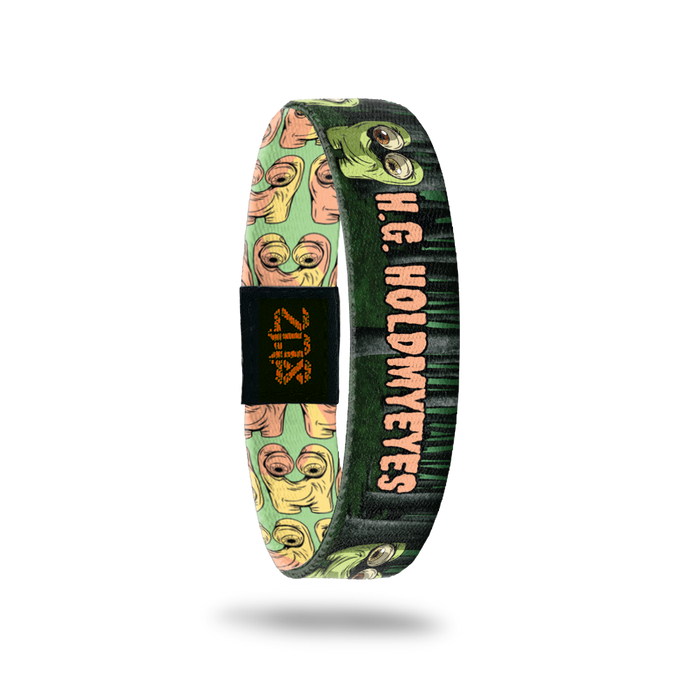 Product photo of the inside of 2020 - Day 18 - H.G. Holdmyeyes: forest design with green monster holding his eyes and orange 'H.G. HOLDMYEYES' text