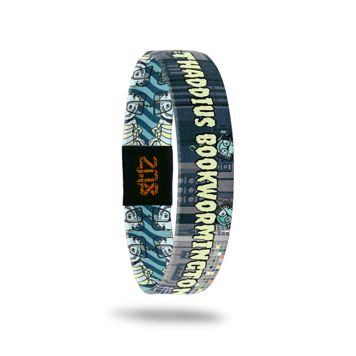 Product photo of the inside of 2020 - Day 24 - Thaddeus Bookwormington: black and gray design with light blue and lime green striped monsters with big glasses and antennas and light green 'THADDIUS BOOKWORMINGTON' text