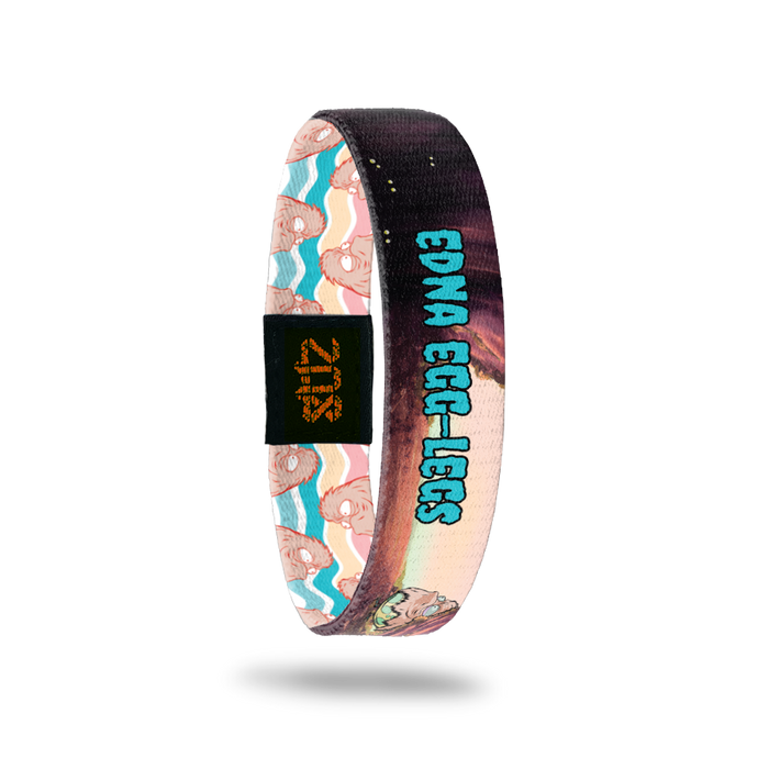 Product photo of the inside of 2020 - Day 31 - Edna Egg-Legs: cave design with furry, peach monster inside a yellow and green egg-shell with teal 'EDNA EGG-LEGS' text