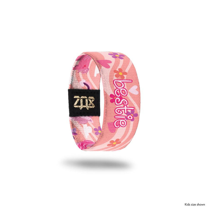 Kid size inside design for Bestie, A pink background with a lighter pink wave that goes across the design. Flowers and hearts in shades of pink and Bestie in white and pink text at the center