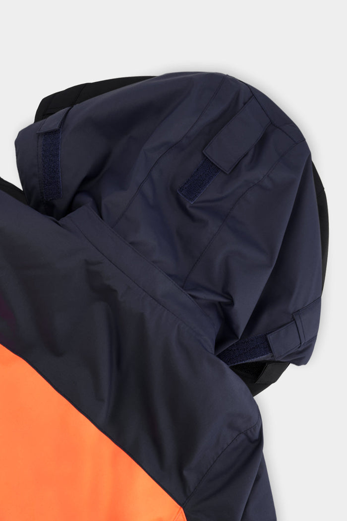 Close-up of the navy helmet-compatible hood on the Deux par Deux TEKNIK one-piece snowsuit