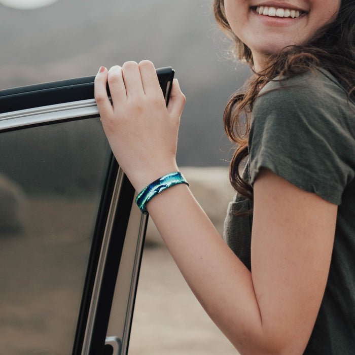 Lifestyle image of someone's hand on a door and wearing Live In The Moment