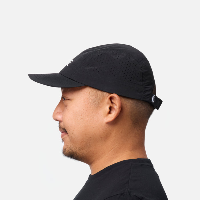 The Run Hat gallery position 1 showing black silhouette with ventilated panels and adjustable strap worn by side-profile model