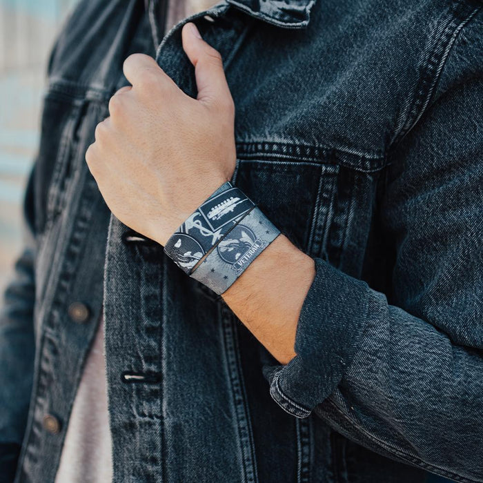 lifestyle photo of a front facing and inside facing Veteran wristband while a man holds onto the front of his jacket