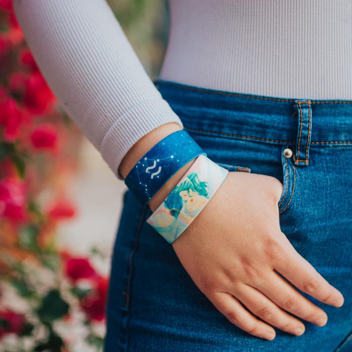 Lifestyle close up image of model's hand in their pocket and wearing two Aquarius straps