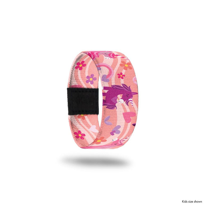 Kid size outside design for Bestie. A pink background with a lighter pink wave that goes across the design. Rainbows and hearts in shades of pink and Unicorns in shades of pink and purple