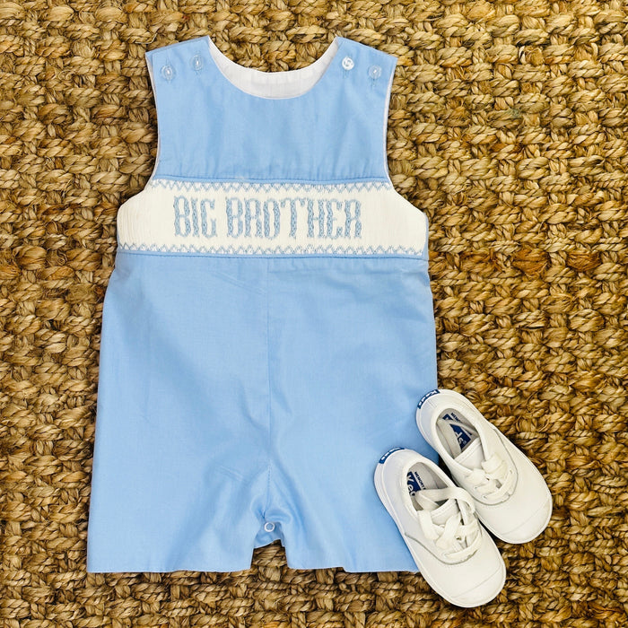 A blue smocked shortall for babies with 'BIG BROTHER' text on the chest