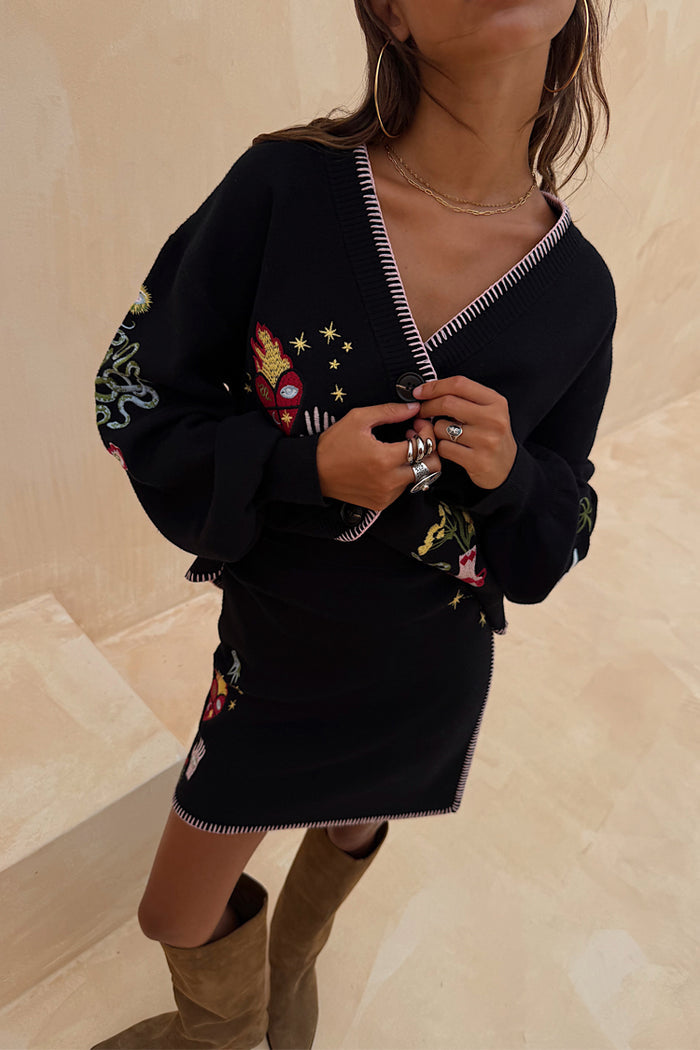 Black Night Garden Mini Wrap Skirt with pink blanket stitch and celestial motifs, styled as a knit co-ord.