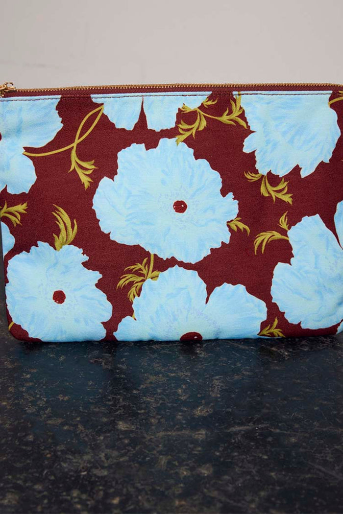 Blue & Burgundy Poppy Laptop Case featuring light blue poppies on a burgundy background with a gold zip.