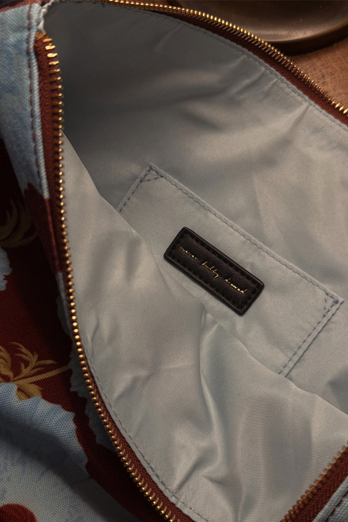 Blue & Burgundy Poppy Laptop Case interior showing the pale blue lining, internal pocket and gold brand label detail.