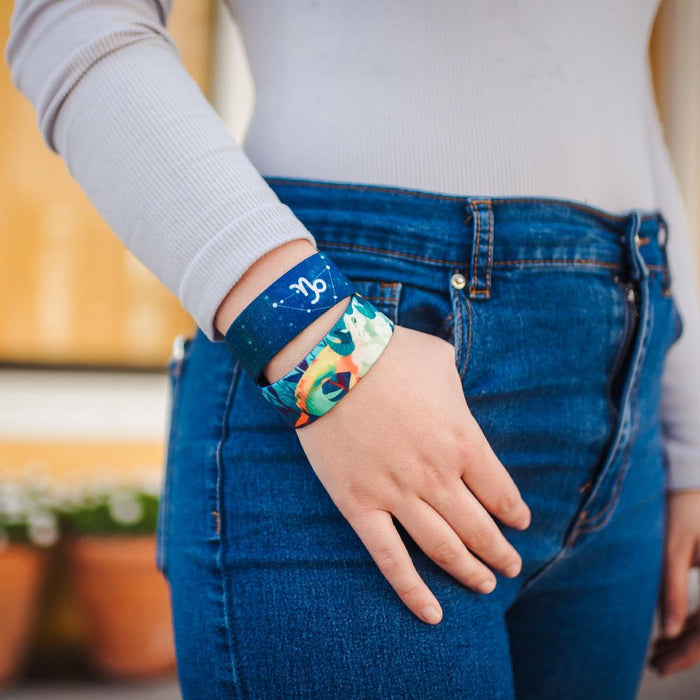 Lifestyle close up image of model's hand in their pocket and wearing two Capricorn straps
