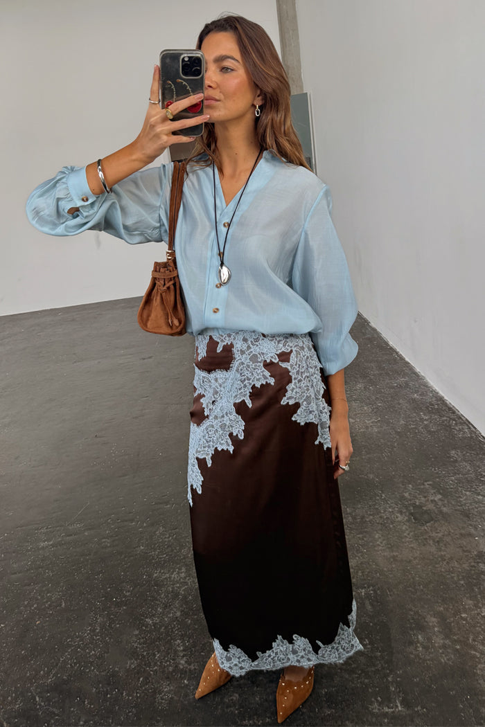 Chocolate Lily Skirt in brown satin with light blue lace detailing, styled for a mirror selfie London look.