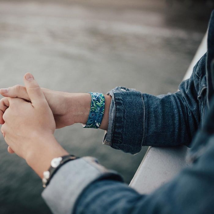 Lifestyle image of someone's arms resting on a railing with Cinephile on one wrist