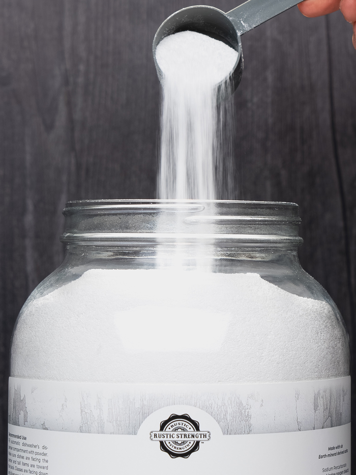 Rustic Strength - White powder being poured from a scoop into a Rustic Strength glass jar