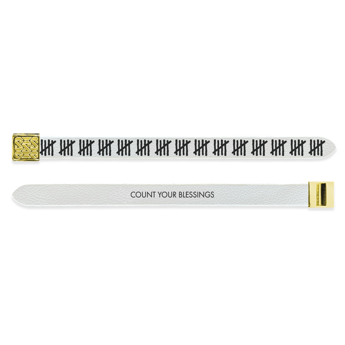 Outside Design of the V2 Imperial Count Your Blessings: vegan leather material with printed on design white background with black tallies and gold buckle clasp Inside Design of the V2 Imperial Count Your Blessings: vegan leather material with printed on design white background with black text ‘Count Your Blessings’ and gold buckle clasp