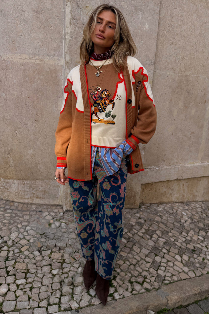 Cowgirl Martha Cardigan in tan knit with red contrast trim and a vintage western yoke with embroidered cowgirl motifs.