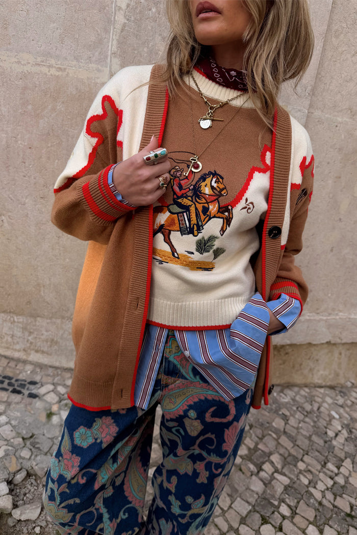 Cowgirl Martha Cardigan in tan with vintage western embroidery and red stitching, layered over a striped shirt.