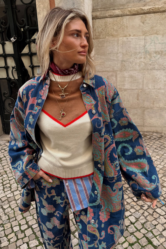 Cowgirl Ro Knitted Tank in cream and tan with red trim, layered with a blue paisley denim jacket and matching trousers.