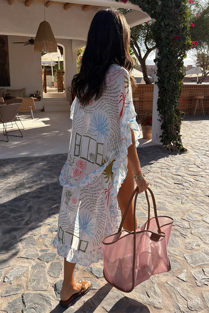 Cream Palma Kimono featuring the Sol De Palma print and frill hem, styled as a vacation cover-up with a pink tote.