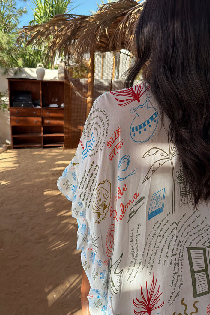 Cream Palma Kimono featuring a hand-painted Sol De Palma print with colourful motifs and scripted poem.