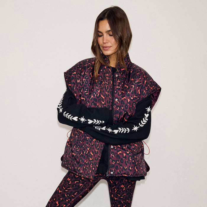 Dark Leopard Gilet in iconic leopard print with a padded water-resistant finish and funnel neck, worn by a model.