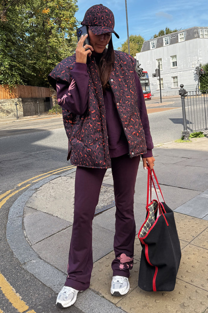Dark Leopard Gilet in a water-resistant padded fabric, styled with a matching cap for a London street look.