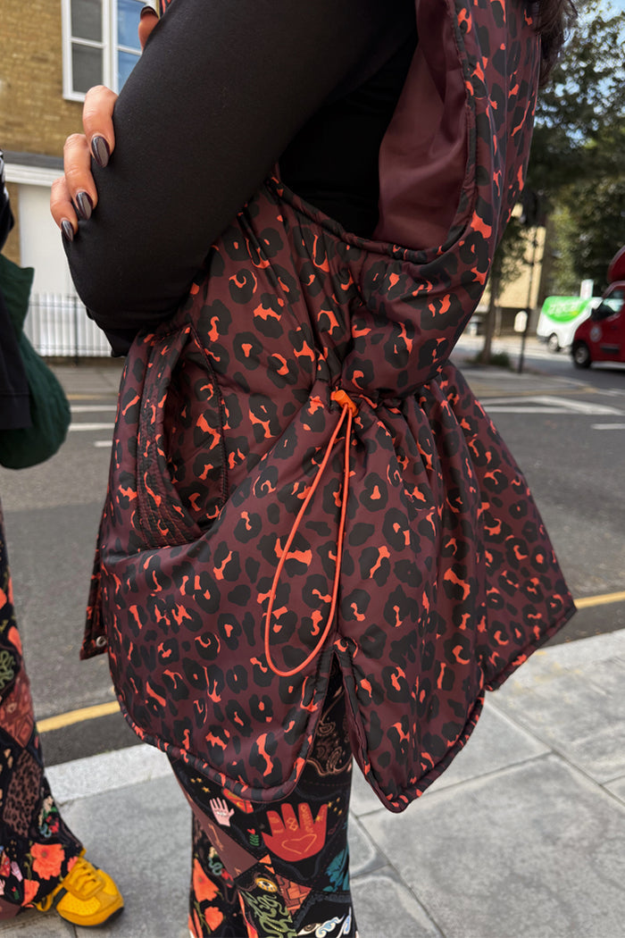 Dark Leopard Gilet featuring a padded silhouette and orange drawstring waist, in our iconic leopard print.