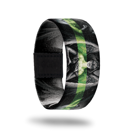 Outside design of Defender, gray scale statue of an angel in the center and two other angels next to the centered angel with a black background. With a green transparent line centered across the design.