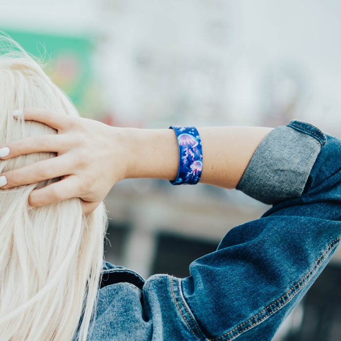 Lifestyle image of someone holding their hand behind their head with an Electric Bloom on their wrist