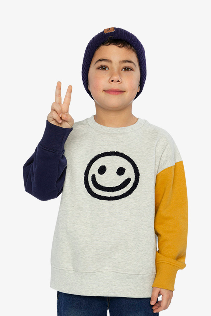 Child wearing Deux par Deux fleece sweatshirt in heather grey, yellow and blue with smiley face graphic, lookbook view 1