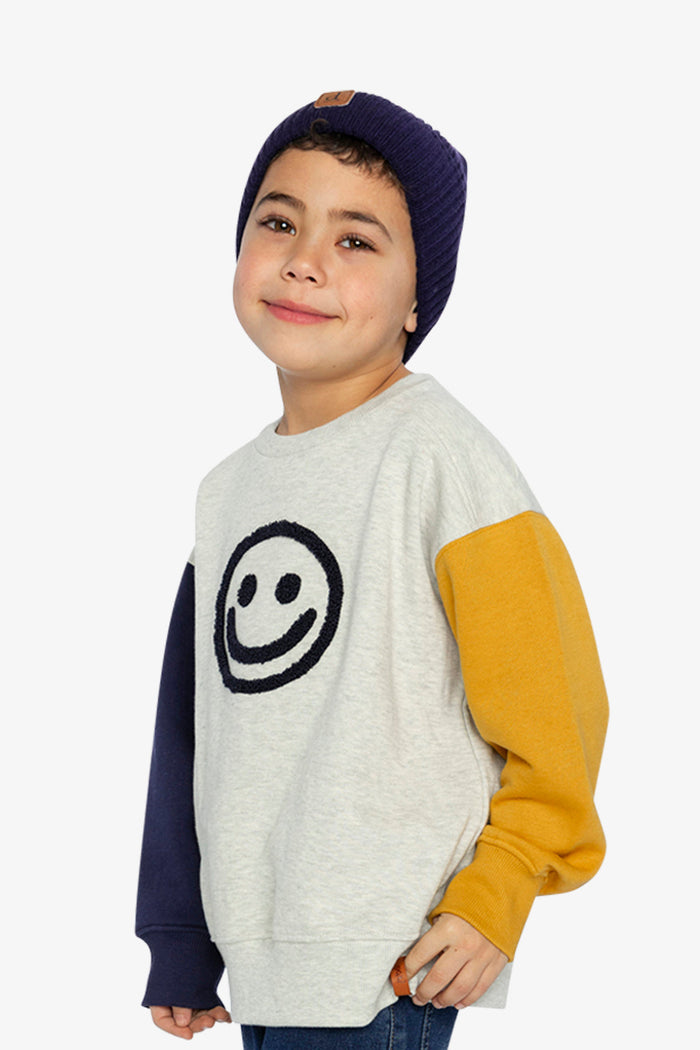 Child wearing Deux par Deux fleece sweatshirt in heather grey, yellow and blue with smiley face graphic, lookbook view 2