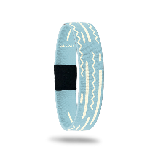 Wristband wih pale blue base and off-white squiggles and lines along the band. Inside reads God's Plan and has Bible verse 24.29.11.