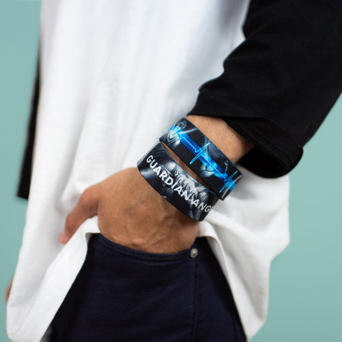 Studio image close up of model's hand in pocket with 2 Guardian Angel on wrist