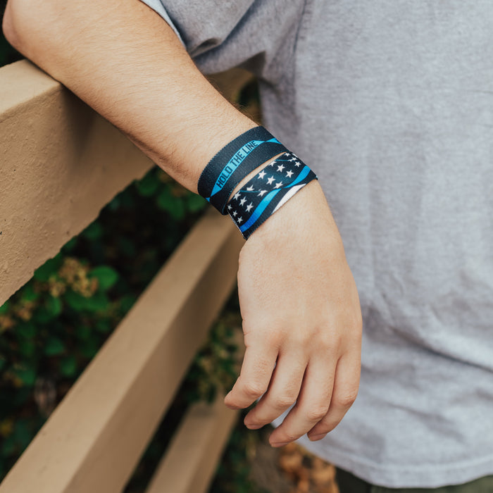Lifestyle image of arm resting on railing with 2 Hold The Line on wrist