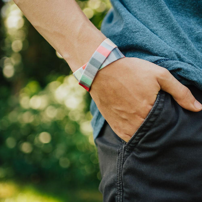 Lifestyle image close up of model's hand in pocket with How Will You Be Remembered? on wrist showing outside design