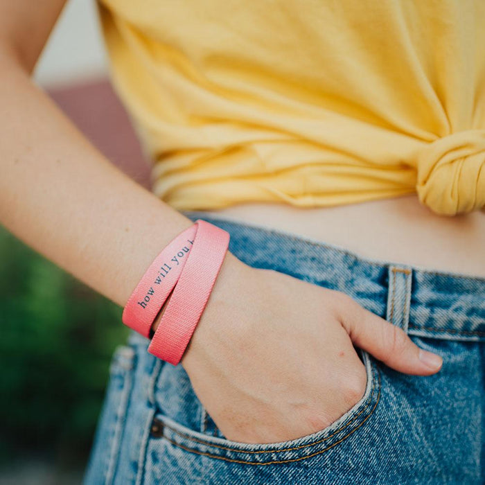 Lifestyle image close up of model's hand in pocket with How Will You Be Remembered? on wrist showing inside design