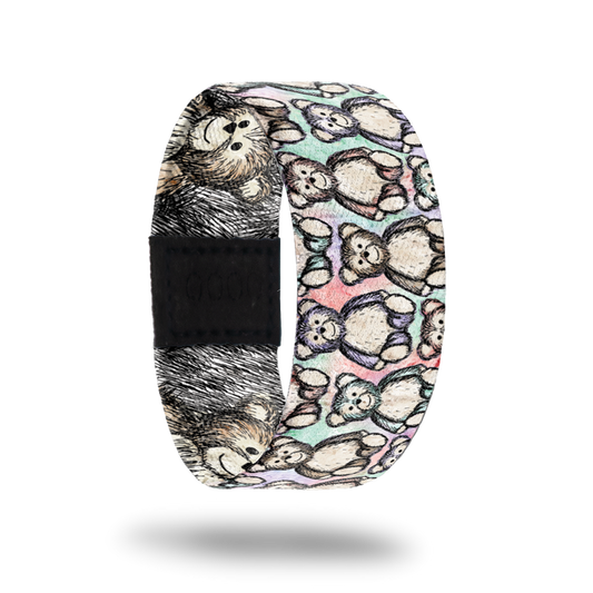Outside design of Hug It Out. Drawn teddy bear pattern over a blended background of light colors of green, pink, and purple. The drawn teddy bears are also randomly light colored green, pink, purple, and yellow