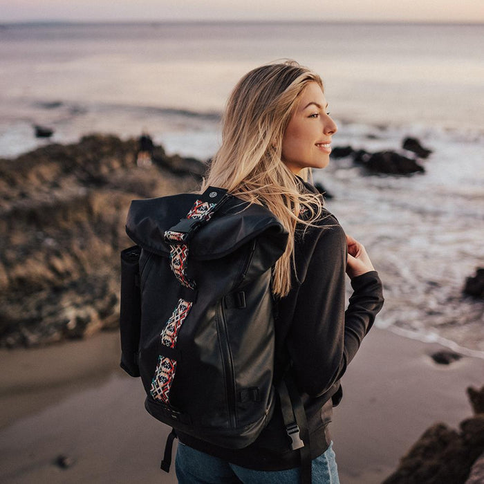 lifestyle photo of the Imperial v2 with a different colored closure strap on a woman's shoulders while at the beach