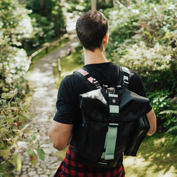 lifestyle photo of the Imperial v2 with a different colored tension and closure strap on a mans shoulders while hiking