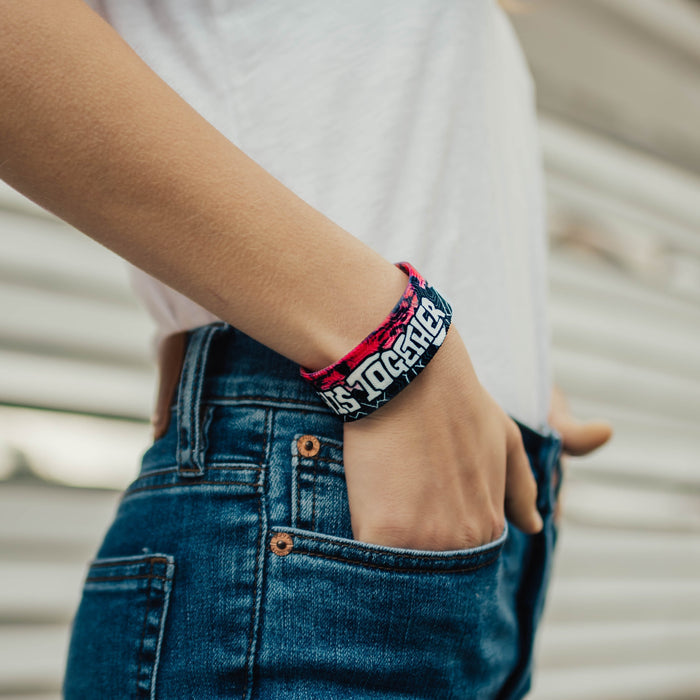Lifestyle image close up of model's hand in pocket with In This Together on wrist