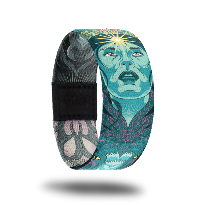 product image of a wristband named Inner Light showing the outside design. The design is hues of blues and greens showing a hand drawn face with a shining star on the person's forehead