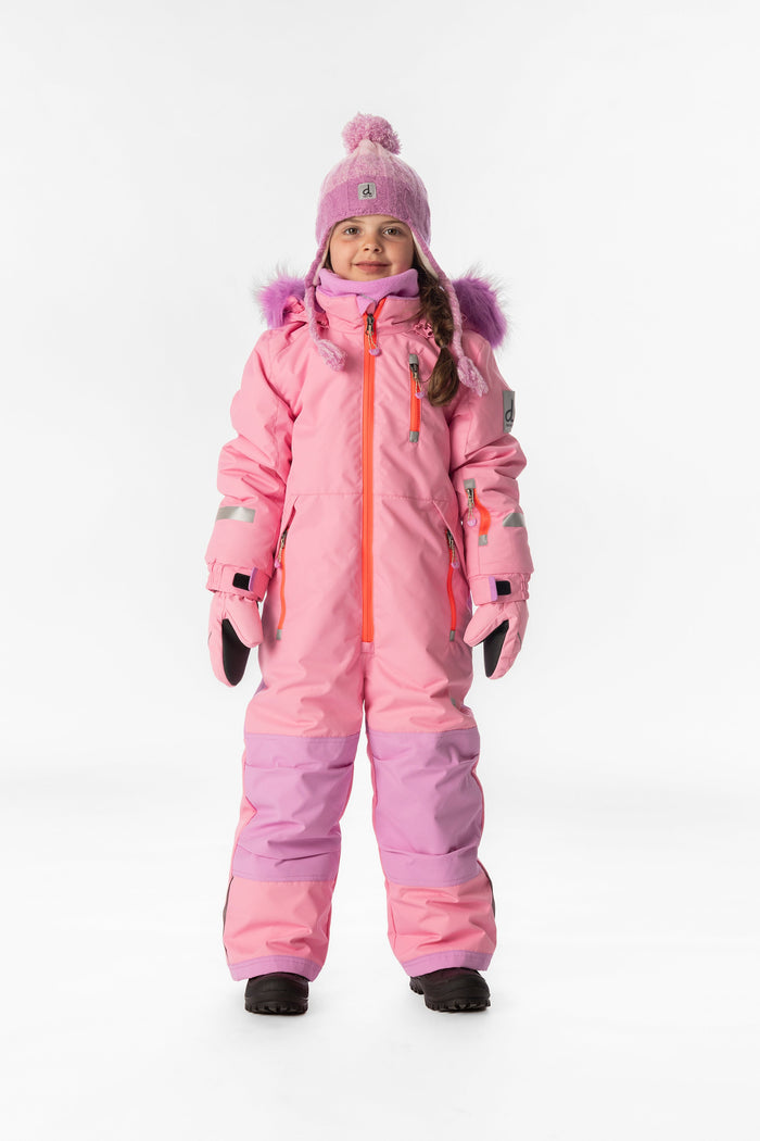 Child wearing the pink Deux par Deux PLAY one-piece snowsuit with a pom-pom hat, front view