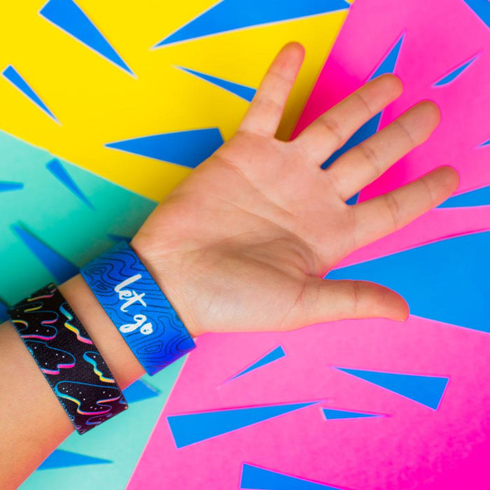 Studio Image of 2 Let Go on a wrist in front of a colorful background