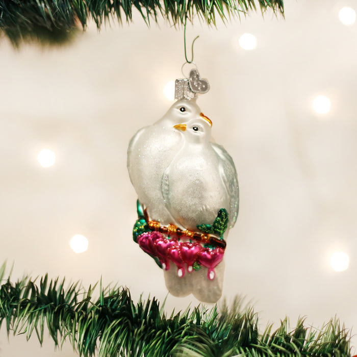 Love Birds glass ornament of 2 white doves hanging on a Christmas tree