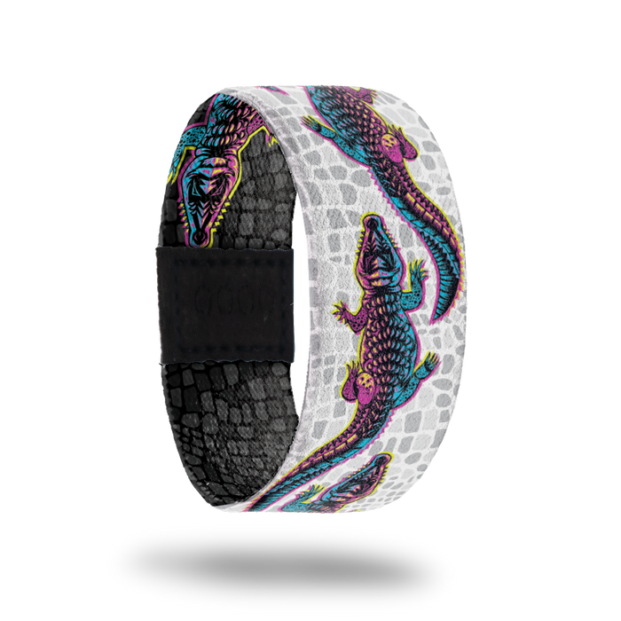 product image of the outside of a wristband called Make your Own Path. The background is a white and grey version of alligator scales. On top are multi-color alligators one after another for the entire design. Each alligator is a gradient that is pink, yellow, and blue
