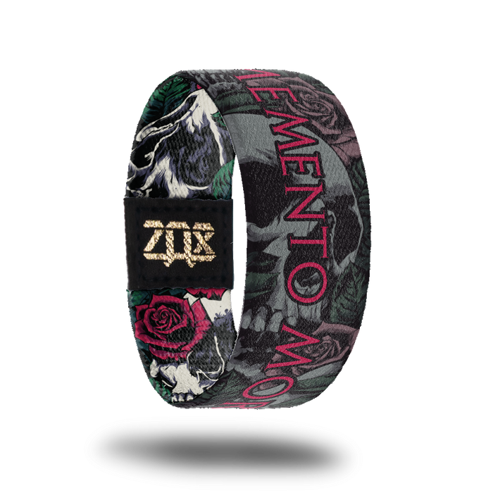 Inside design for Memento Mori. Gray illustrated realistic skulls, roses, and leafs with Memento Mori in red text at the center