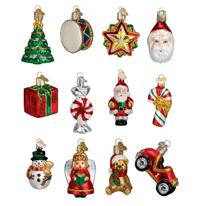 Twelve colorful Christmas ornaments shaped like a tree, drum, star, Santa faces, gift box, peppermint candy, Santas, snowman, angel, teddy bear, and red motorcycle, all with gold hanging loops.