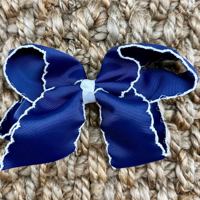 A royal blue grosgrain ribbon bow with white trim,