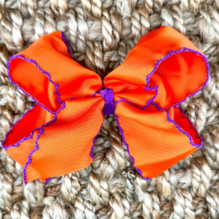 An orange grosgrain ribbon bow with purple ruffled trim clemson