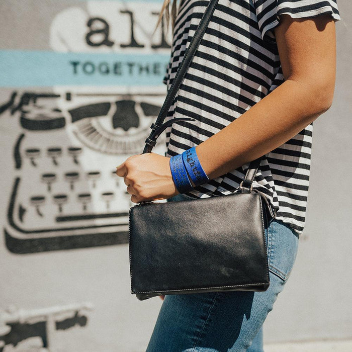 Lifestyle image of someone holding their purse with 2 Nightfall on their wrist